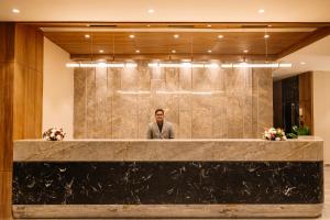 a man standing behind a counter in a lobby at Pride Premier Alwar - Sariska in Alwar +51 photos
