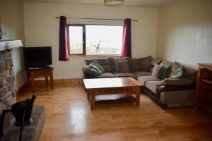 ein Wohnzimmer mit einer Couch und einem Couchtisch in der Unterkunft West Kerry House Camp in Tralee