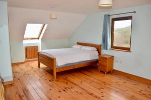 ein Schlafzimmer mit einem Bett und einem Fenster in der Unterkunft West Kerry House Camp in Tralee
