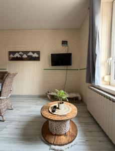 Appartement La Vanne Confortable et équipé في لابريس: غرفة معيشة مع طاولة وتلفزيون