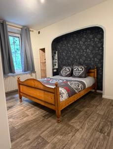 Appartement La Vanne Confortable et équipé في لابريس: غرفة نوم بسرير خشبي مع لوح أمامي كبير