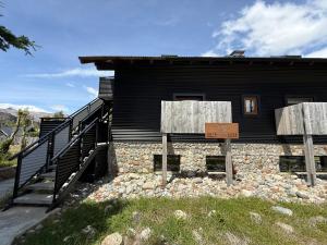 a black building with a sign in front of it at Campo Base Aparts in El Chalten