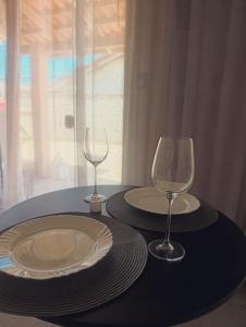 two plates and wine glasses sitting on a table at Vila Mar Lofts in Barra Velha
