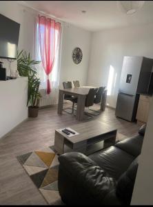 Appartement confortable Andrezieux Boutheon في Bouthéon: غرفة معيشة مع أريكة وطاولة +4 صور