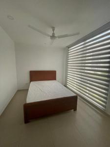 Casa Moderna en Condominio Ricaurte - Girardot في جيراردو: غرفة نوم بها سرير ونافذة بها ستائر