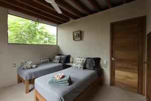 Villa Cuachalalate - Puerto Escondido في El Puertecito: غرفة نوم بها سريرين ونافذة