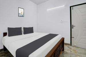 a bed with black and white pillows in a room at Hotel O EVA RESIDENCY in Cochin