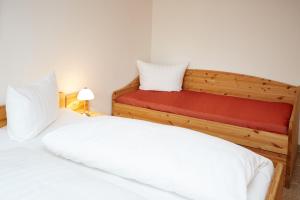 オーベルストドルフにあるFerienwohnung Ewersのベッドルーム1室(ベッド2台、赤いマットレス付)