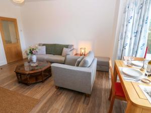 a living room with a couch and a table at Mains Cottage in Consett