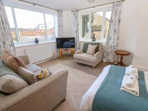 a living room with a bed and a couch and windows at Mains Cottage in Consett