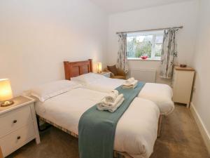 two twin beds in a room with a window at Mains Cottage in Consett