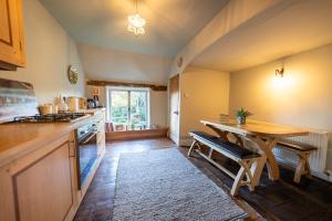 a kitchen with a wooden table and a wooden floor at The Old Rectory Framlingham in Framlingham