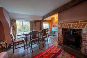 a living room with a fireplace and a table and chairs at The Old Rectory Framlingham in Framlingham