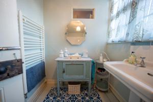 bagno con lavandino blu e vasca di The Old Rectory Framlingham a Framlingham Altre 19 foto