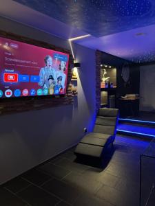 a room with a large screen on a wall at Apartment - Jacuzzi - Sauna in Voiron