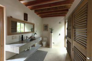 Villa Cuachalalate - Puerto Escondido في El Puertecito: حمام مع حوض و مرآة و مرحاض +73 صورة