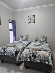 Dos camas una al lado de la otra en un dormitorio. en Urban Park Apartments, en Durban
