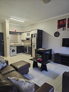 una sala de estar con un sofá y una mesa en Urban Park Apartments, en Durban