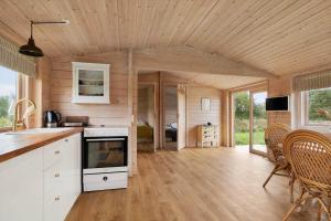 a kitchen and living room with wooden walls and ceilings at 20158-Samso-Laerkevej-13 in Mårup +23 photos