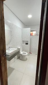 a white bathroom with a toilet and a sink at Cerquita del Cielo in San Bernardino +11 photos