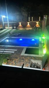a blue swimming pool at night with lights at Cerquita del Cielo in San Bernardino