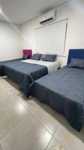 two beds sitting in a room with a white wall at Cerquita del Cielo in San Bernardino