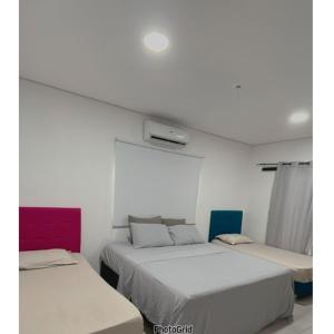 two beds in a room with white walls at Cerquita del Cielo in San Bernardino