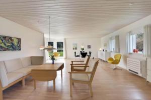 un soggiorno con un divano, un tavolo e delle sedie di LK2197-Lokken-Molleager-1 a Lyngbytorp