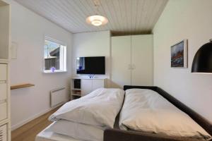una camera da letto con un letto e una TV a schermo piatto di LK2197-Lokken-Molleager-1 a Lyngbytorp