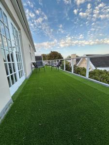 a balcony with green grass and benches on a building at Serenity Green House near Constantia Winelands in Square Hill