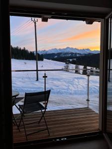 Tatra Widok في بوكافينا تترايسكا: منظر لسطح به كرسي وحقل مغطى بالثلوج