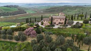 an aerial view of a house on a hill with trees at Podere Cunina in Buonconvento
