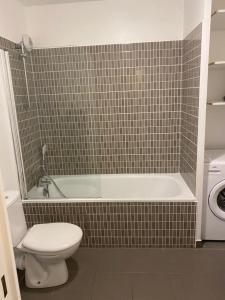 a bathroom with a toilet and a tub and a sink at Beau 2 pièces moderne et cosy à Corbeil-Essonnes in Corbeil-Essonnes