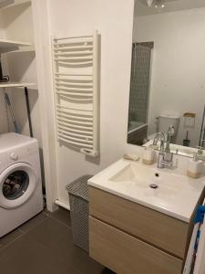 a bathroom with a sink and a washing machine at Beau 2 pièces moderne et cosy à Corbeil-Essonnes in Corbeil-Essonnes