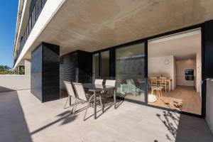 阿普利亚GuestReady - Seaside oasis in private condo的阳台,配有桌椅