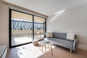 阿普利亚GuestReady - Seaside oasis in private condo的带沙发和大窗户的客厅