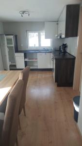 a kitchen with white cabinets and a wooden floor at Apart Stefan Niederthai in Niederthai