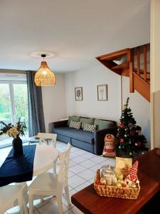 a living room with a christmas tree and a couch at Le Patis in Mignaloux-Beauvoir