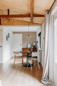 Boshuisje Noi op de Veluwe في Hattemerbroek: غرفة طعام بها طاولة وكراسي +25 صورة