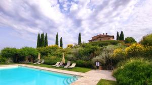 a swimming pool in a garden with a house on a hill at Podere Cunina in Buonconvento