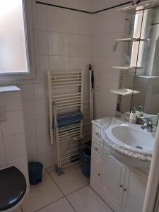 a white bathroom with a sink and a mirror at Prieuré Maisons-Laffitte in Maisons-Laffitte