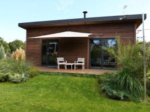 een huis met een paraplu en een tafel en stoelen bij Dom na rozlewiskach in Nowe Warpno +10 foto's