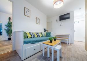 ein Wohnzimmer mit Sofa und Tisch in der Unterkunft The Paris 9th Sky - 8min to Paris in Saint-Denis