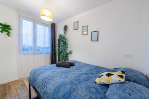 ein Schlafzimmer mit einem blauen Bett und einem Fenster in der Unterkunft The Paris 9th Sky - 8min to Paris in Saint-Denis