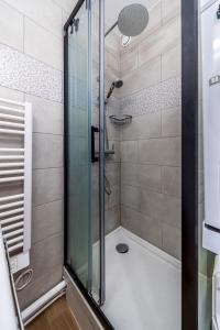 eine Dusche mit Glastür im Badezimmer in der Unterkunft The Paris 9th Sky - 8min to Paris in Saint-Denis