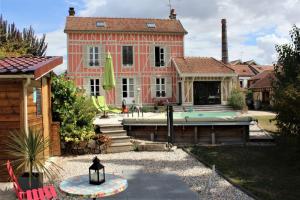 a large house with a swimming pool in front of it at La chabrouchine in Sainte-Savine