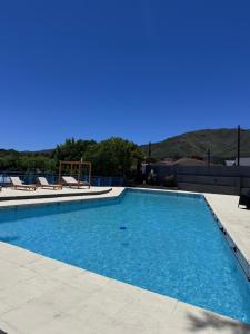 una piscina con agua azul en un edificio en Hotel Santa Bárbara, en La Falda
