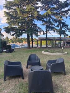 Un grupo de sillas en un parque con un árbol. en Hotel Santa Bárbara, en La Falda