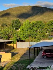 un coche aparcado en un aparcamiento frente a una montaña en Hotel Santa Bárbara, en La Falda
