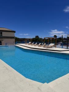 una gran piscina con sillas en un edificio en Hotel Santa Bárbara, en La Falda